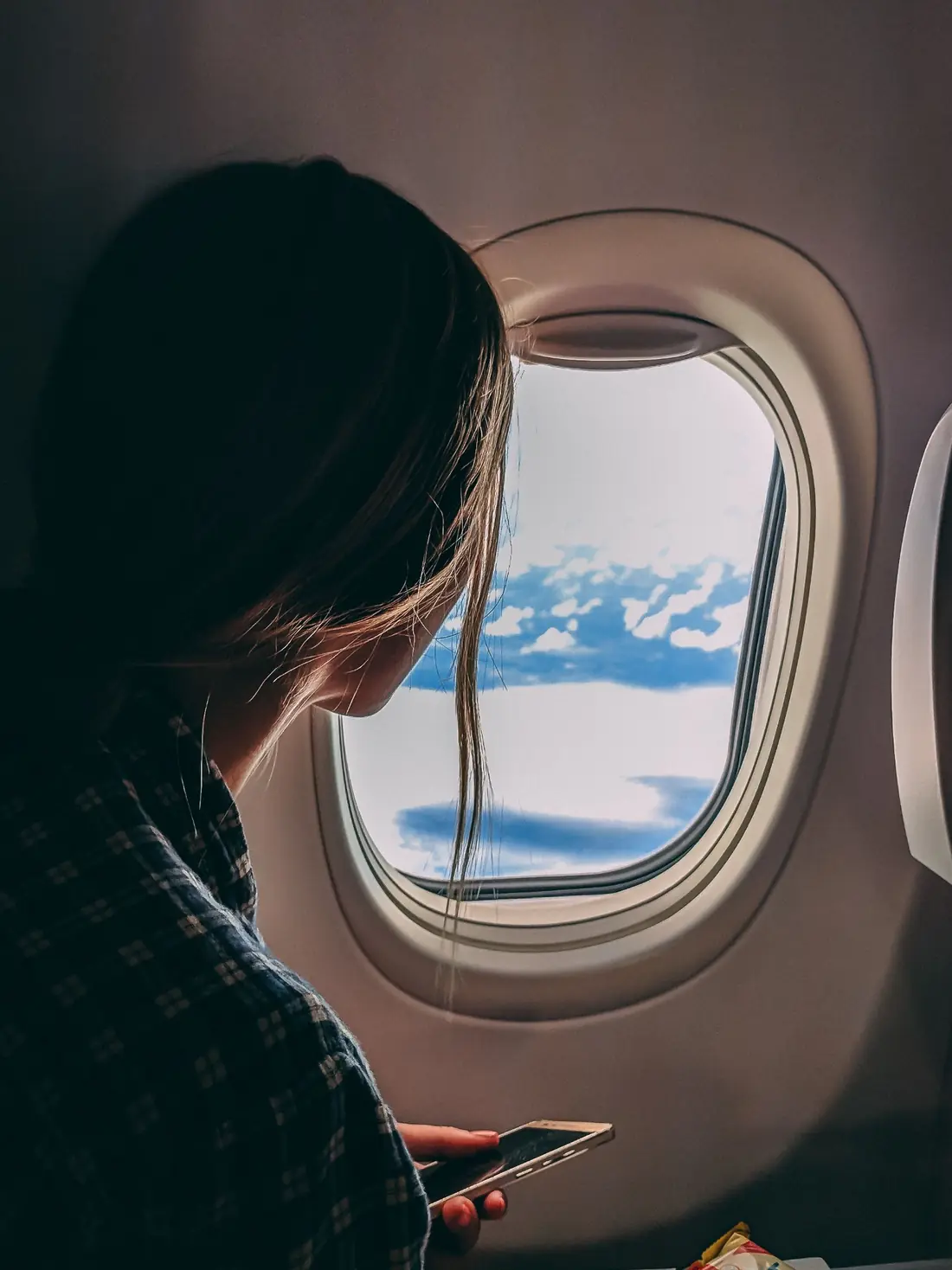 Woman traveller looking through an aircraft window